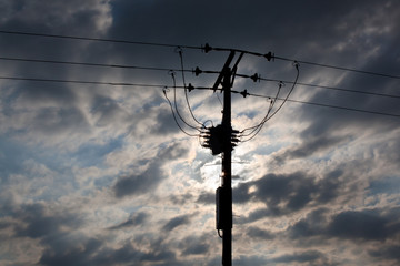 sun behind power lines
