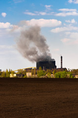 Fototapeta na wymiar Dark smoke rising from the power plant against blue background