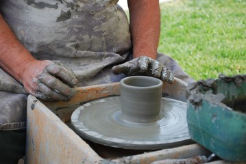 Man shaping clay on potters wheel to become a vase