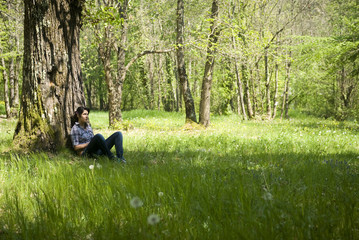 Teenage girl relaxing under a tree