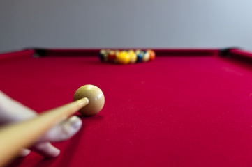 Balls on a red pool table with player