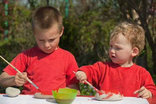 Kinder bemalen Steine