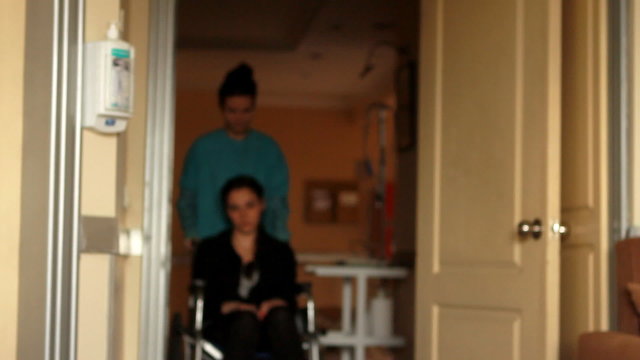 nurse carrying patient on a wheelchair