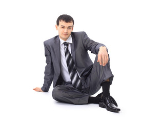 Handsome businessman sitting on the floor . Isolated