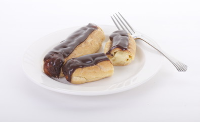 Two Chocolate Eclairs on a White Plate with Fork