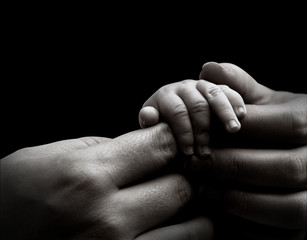 Baby hand holding mother's hands