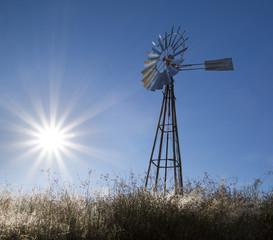 Windmill with sun rising blue sky