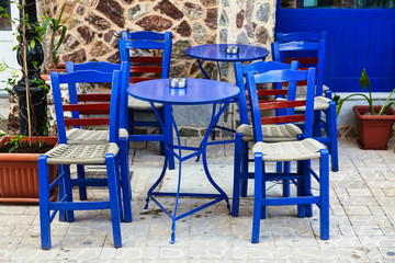Fototapeta na wymiar Blue chairs on a greek cafe