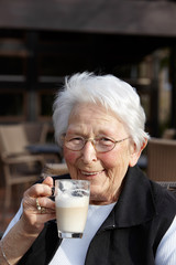 Nette alte Dame Portrait im Cafe trinkend 3