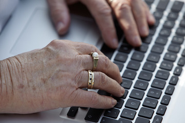 Seniorenhände auf Laptop 2