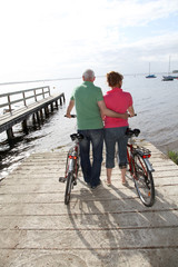 Obraz premium Senior couple on bicycle ride by a lakeside