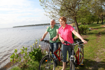 Obraz premium Senior couple on bicycle ride by a lakeside