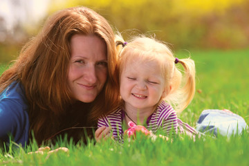 mother with child lying on a grass