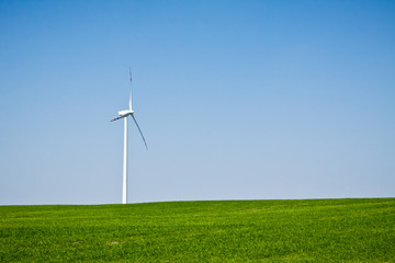 Fototapeta premium Wind turbine on green field