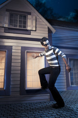 Thief walking on the roof of a house at night