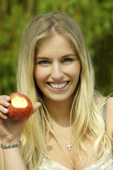 Junge Frau isst einen Apfel