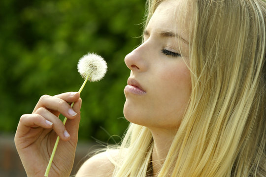 Junge Frau mit einer Pusteblume