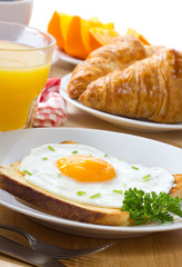 breakfast with  fried egg, juice and croissant