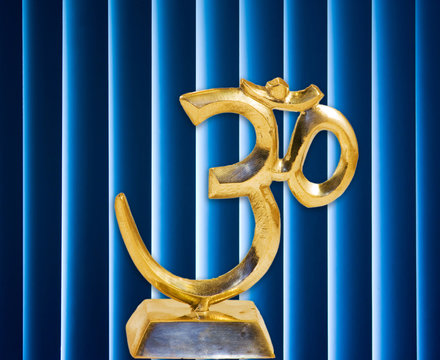 golden Om in base with dark and with glowing blue background
