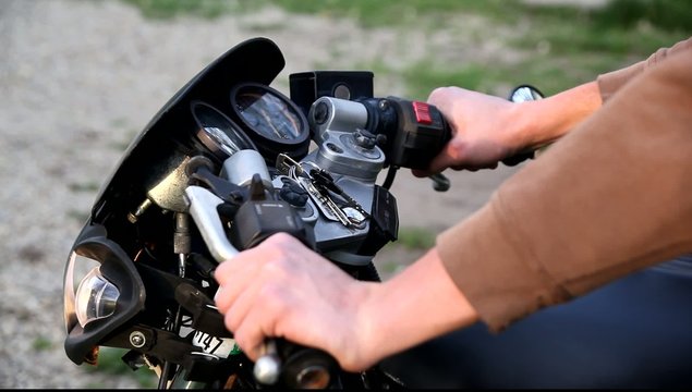 Close-up hands revving a motorcycle