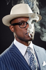 Fototapeta na wymiar Black man with blue striped suit and white hat smoking.