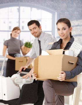 Happy businesspeople moving to new office