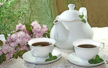 Teapot and cup of tea with mint