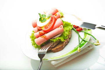 Brown bread with chili sausage slices green salad tomato and egg