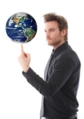 Goodlooking man balancing a globe on forefinger