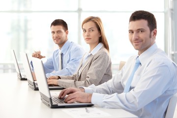 Obraz premium Young businesspeople working on laptop smiling