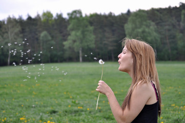 Junge Frau mit Pusteblume