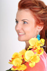 Fototapeta premium Red-haired woman with yellow orchid