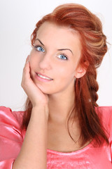 Fototapeta premium Beautiful red-haired woman in pink smiling