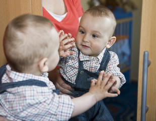 Baby boy looking in the mirror
