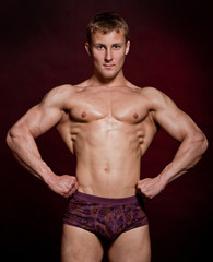 Fototapeta na wymiar Strong wet sexy nude young bodybuilder posing