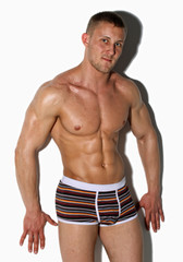 Fototapeta premium Strong wet sexy nude young bodybuilder and his shadow