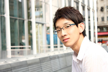 businessman sitting on a bench in front of an office building