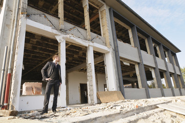 Mann auf der Baustelle vor entkernter Fassade