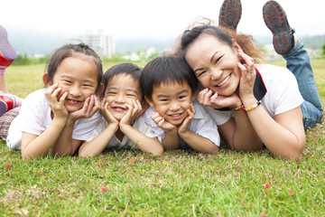 asian mother and her children on the green field