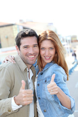 Portrait of smiling couple with thumbs up