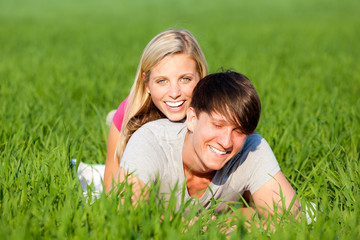 Fototapeta premium pärchen liegt lachend auf der wiese