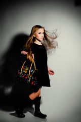 Fashion little girl with bag posing in the studio