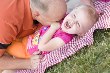 Loving Dad Tickles Daughter in Park