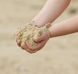 mains d'enfant à la plage