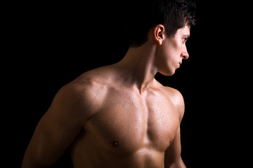 Atractive muscular young man against black background