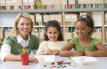 Fototapeta premium Kindergarten teacher sitting with students in art class