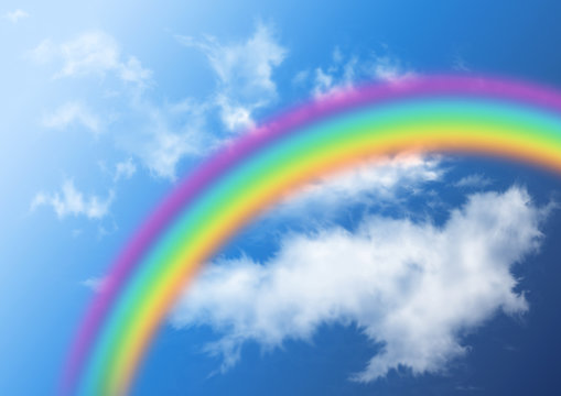 Rainbow in clouds and to the blue sky