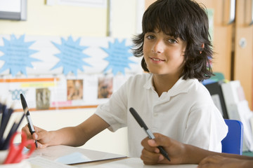 A schoolboy studying in class