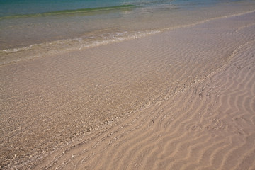 Transparent sea water ripple on the beach background