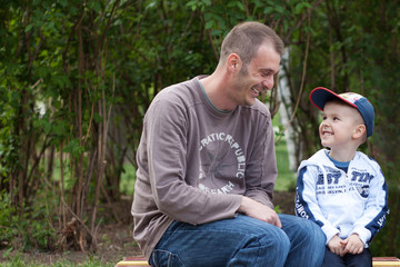 Father and son laughing in park